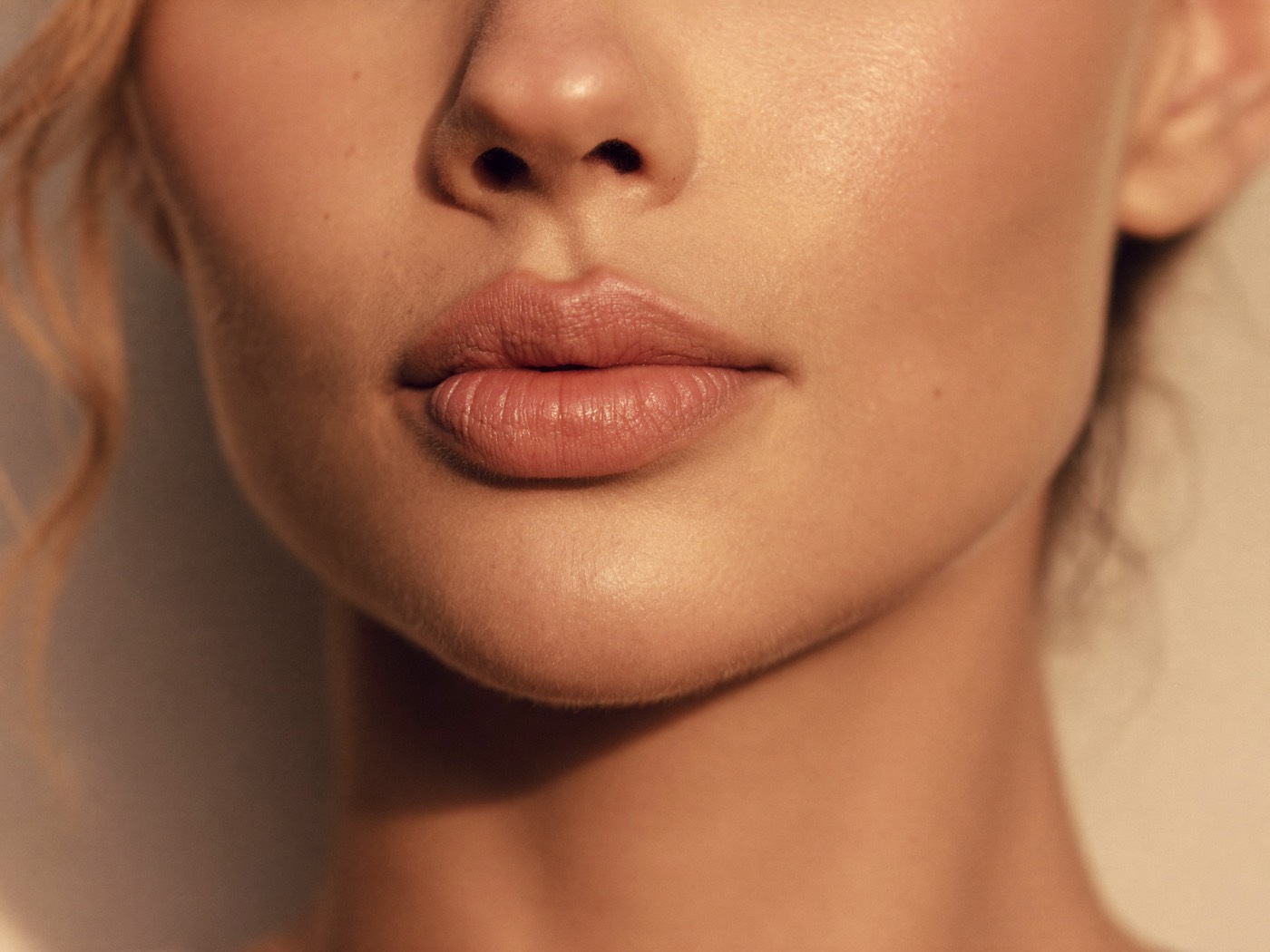 Woman with naturally full, softly defined lips in warm golden light