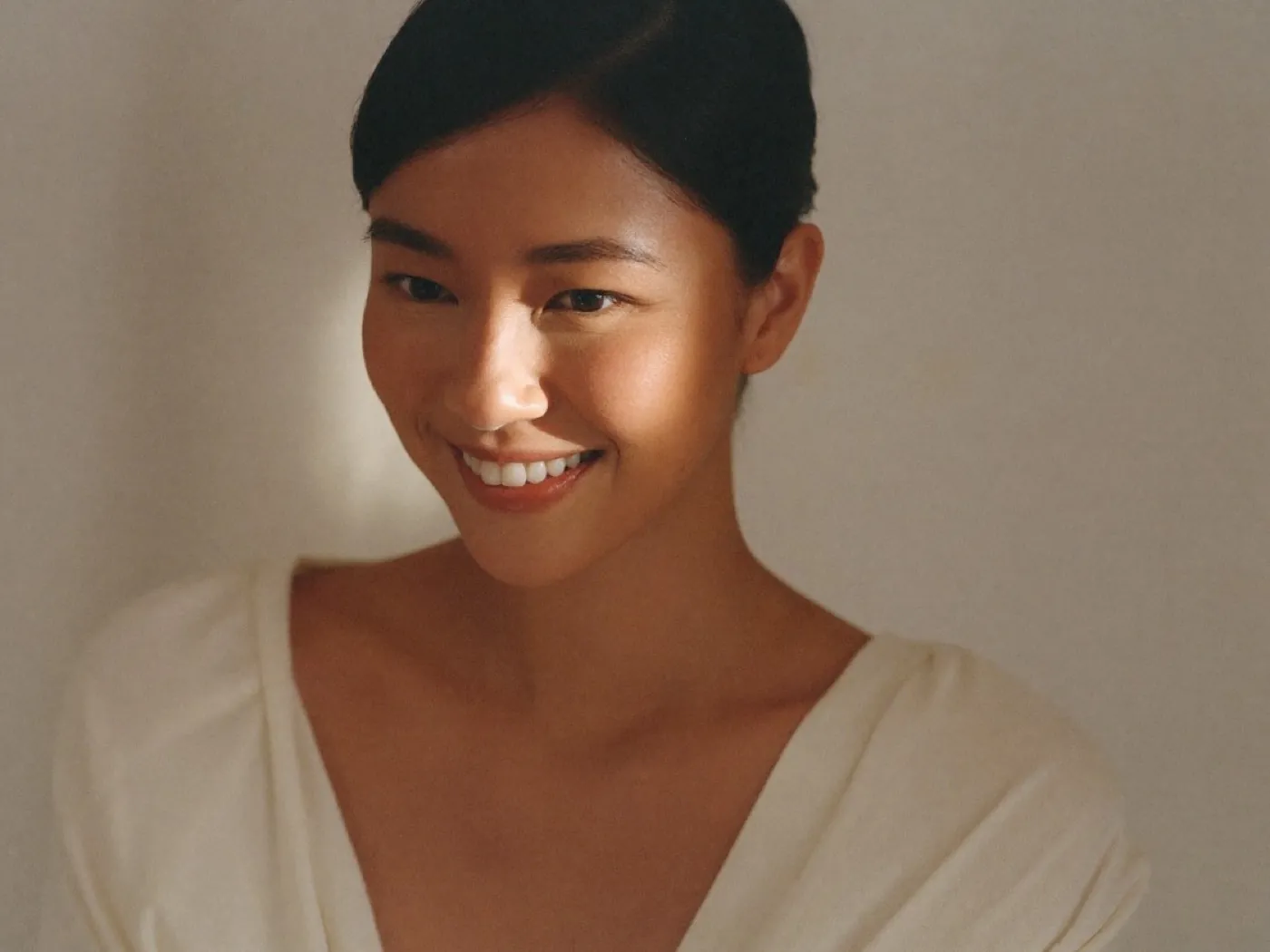 A woman with a soft, natural expression in warm light
