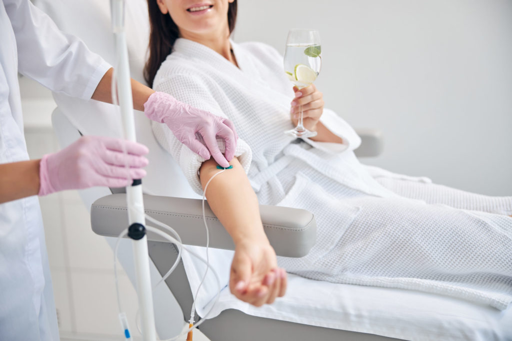 Smiling female patient undergoing intravenous vitamin therapy in Beleza Medical Aesthetics and Wellness in Severn, MD